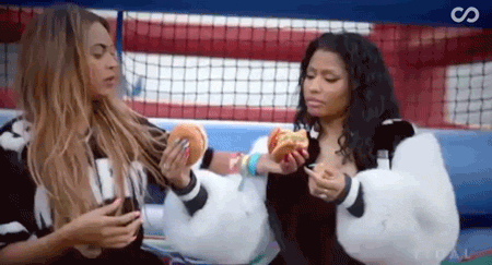 Nicki Minaj and Beyoncé feed each other burgers.